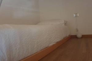 A bed or beds in a room at LA FINESTRA SUL FIUME-GRAZIOSA MANSARDA.CIR 014O74