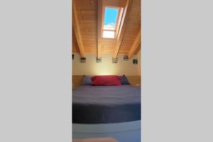 A bed or beds in a room at LA FINESTRA SUL FIUME-GRAZIOSA MANSARDA.CIR 014O74