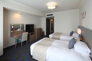a hotel room with two beds and a desk at Shibuya Excel Hotel Tokyu in Tokyo