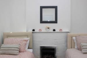 ein Wohnzimmer mit einem Kamin und einem Spiegel in der Unterkunft Newly Refurbished 3 Bed 2.5 Bath House in Staines in Staines