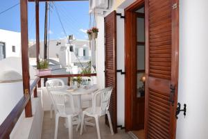 a white table and chairs on a balcony with a door at Naoussa Center Cycladic House in Kampos Paros