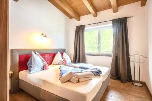 a bedroom with a bed with pillows and a window at Appartementhaus Tanja in Ellmau