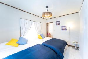 ein Schlafzimmer mit einem großen Bett mit blauen und gelben Kissen in der Unterkunft Awaji egaosakuie tonouchi in Awaji