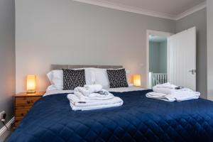 ein Schlafzimmer mit einem blauen Bett und Handtüchern darauf in der Unterkunft The Old Clubhouse in Copley