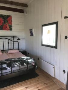 Schlafzimmer mit einem Bett und einem Fenster in der Unterkunft Tågmagasinet Fidenäs in Burgsvik