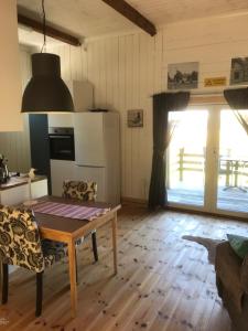 a living room with a table and a kitchen at Tågmagasinet Fidenäs in Burgsvik