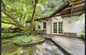 a porch of a house with a tree in front of it at Jacomb's Cottage and Studio in Walhalla