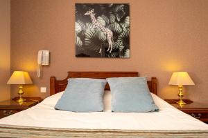a bedroom with a bed with two pillows at Hotel Aguado in Dieppe