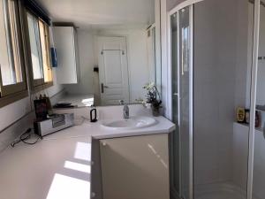 a white bathroom with a sink and a shower at Esterel Terrasses, roof top, 10mn Palais des festivals in Cannes