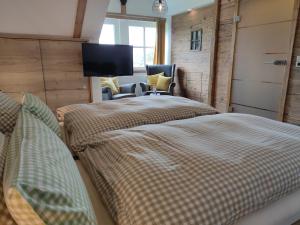 2 Betten in einem Zimmer mit einem TV an der Wand in der Unterkunft Gasthof Dörsbachhöhe in Herold