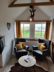 a living room with two chairs and a table at Gasthof Dörsbachhöhe in Herold