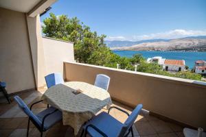 una mesa y sillas en un balcón con vistas al agua en Apartments Mia en Pag