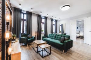 sala de estar con sofá verde y 2 sillas en Modern Apartments Toruń 3, en Toruń