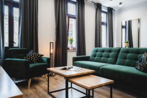 a living room with a green couch and chairs at Modern Apartments Toruń 3 in Toruń