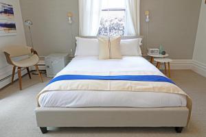 a bed room with a white bedspread and a white comforter at The Hotel Marblehead in Marblehead