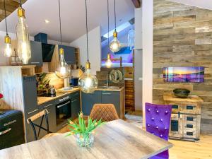 a kitchen with a wooden table and purple chairs at Ferienhaus auf der Schleuseninsel in Lahnstein