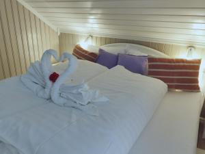 two swans made out of towels on a bed at BanPim Beachside Lofoten in Ramberg