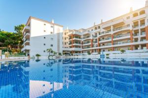 a hotel room with a swimming pool and a balcony at AP Victoria Sports & Beach in Albufeira