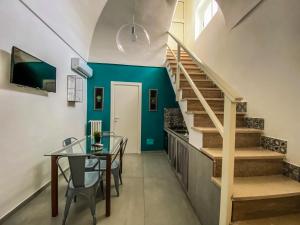 a dining room with a glass table and stairs at Diomede Rooms - Manfredi Homes&Villas in Manfredonia