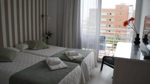 a hotel room with two beds and a window at Apartamentos Calma Rentals in Torremolinos