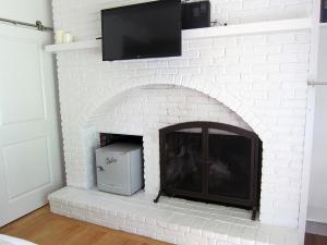 een witte bakstenen open haard met een tv erbovenop bij The Hotel Marblehead in Marblehead +48 foto's