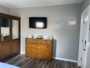 a bedroom with a dresser with a television on the wall at Murphys Law Inn 2 in Leeds
