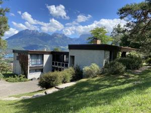 a house on a hill with mountains in the background at Le Grand Praz in Saint-Jorioz +27 photos