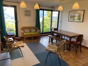 a living room with a wooden table and chairs at Le Grand Praz in Saint-Jorioz