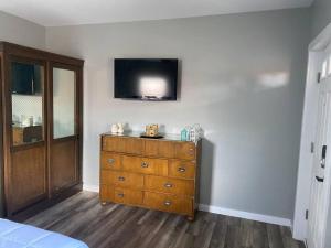 a bedroom with a dresser and a tv on a wall at Murphys Law Inn 3 in Leeds