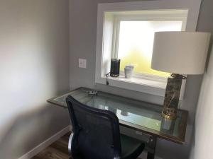 a desk with a chair and a lamp and a window at Murphys Law Inn 4 in Leeds