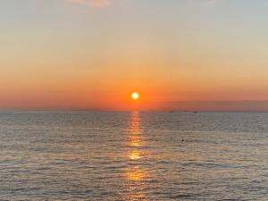 een zonsondergang boven de oceaan met zonsondergang bij Awaji egaosakuie tonouchi in Awaji