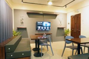 a waiting room with tables and a tv on the wall at Mint Homes in CEV Mansion in Manila