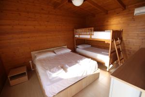 a bedroom with two bunk beds in a wooden cabin at Bunec Beach Resort in Piqeras