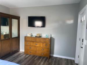 a bedroom with a dresser with a television on the wall at Murphys Law Inn 7 in Leeds