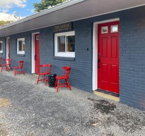 a group of red chairs outside of a building with a red door at Murphys Law Inn 7 in Leeds