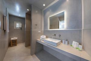 a bathroom with a sink, toilet and bathtub at Secret View Hotel in Oia