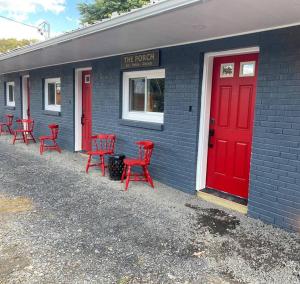 eine Gruppe roter Stühle vor einem Gebäude mit roter Tür in der Unterkunft Murphys Law Inn 1 in Leeds