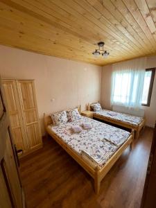 席闊維沙爾克的住宿－Къщи Мaхони，一间卧室设有两张床和木制天花板