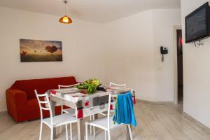 カステッランマーレ・デル・ゴルフォにあるBorgo Aranci - Villetta a Schiera A1のリビングルーム(テーブル、椅子、赤いソファ付)