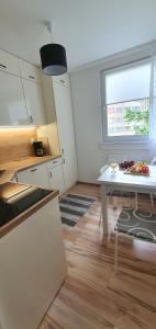 a kitchen with a white table and a window at Apartament Łąkowa in Polanica-Zdrój