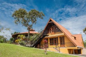 a house with a balcony and a tree at San Agustin Internacional Hotel in San Agustín