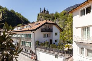 a view of a building with a hill in the background at Mondschein Rooms in Lana