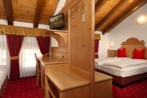 a hotel room with two beds and a television at Hotel Gardenia in Passo del Tonale