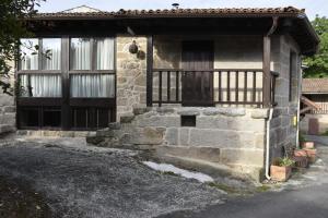 a stone house with a door and a balcony at Ribeira sacra ourense in Ourense