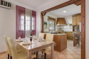 cocina y comedor con mesa y sillas en Casa Ainhoa, en Conil de la Frontera
