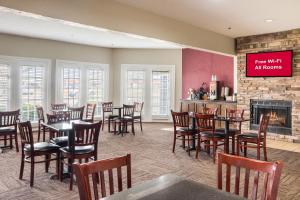 a restaurant with tables and chairs and a fireplace at Red Roof Inn Dumas in Dumas
