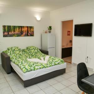 1 dormitorio con 1 cama y TV en la pared en Cseresznyés Apartman en Berekfürdő