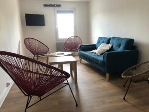a living room with a blue couch and chairs at Le Gîte du Jard in Épernay