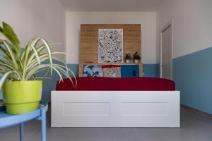 um quarto com uma cama branca e um cobertor vermelho em Casa di Marco Lungomare Jonio em Lido Conchiglia
