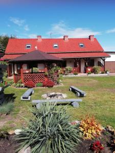 a house with a red roof in a yard at Apartamenty Kołczewo in Kołczewo